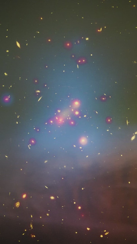 Stars and galaxies in space through a yellow cloud.