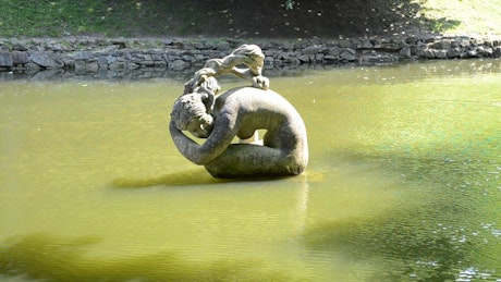 Statue sitting in a pond.