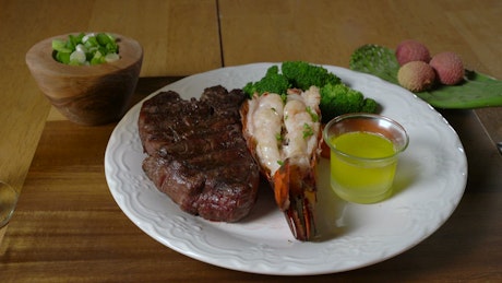 Steak and lobster with vegetables.