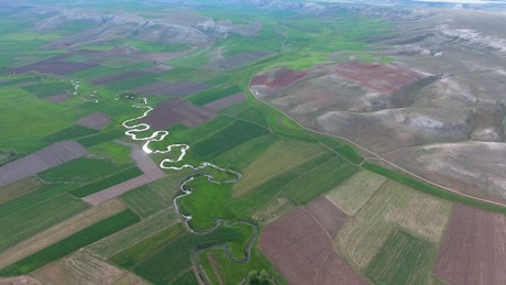 Stream between sgricultural fields in a wide valley