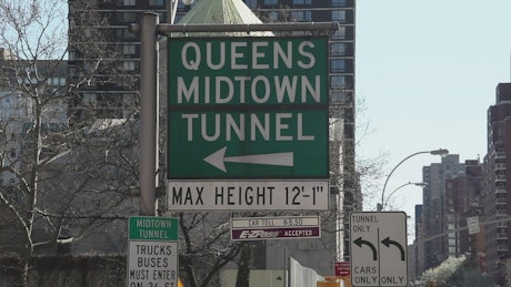 Street signs leading to a tunnel.