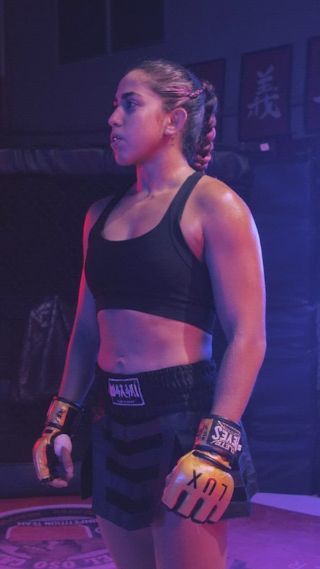 Strong female fighter standing on a ring.