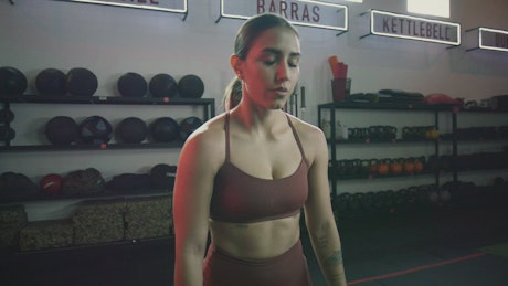 Strong woman doing weightlifting in a gym.