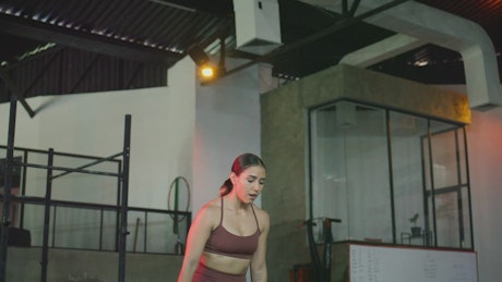 Strong woman exercising with a platform in a gym.