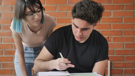 Student confused with homework is helped by her classmate