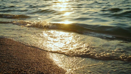 Sun reflections and gentle waves in the beach.