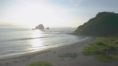 Sunny coast with a beach and a peninsula.