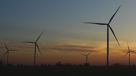 Sunset in the countryside with wind turbines working.