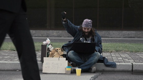Super excited homeless man with a laptop.