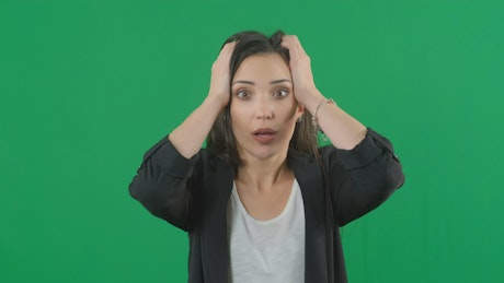 Surprised woman with a green background.