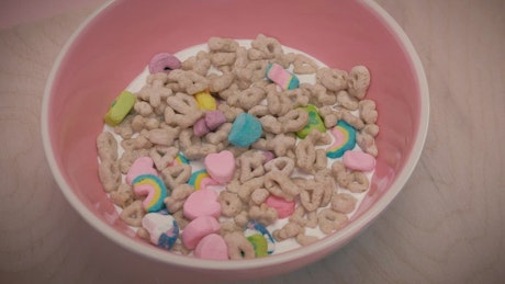 Sweetened cereal with marshmallows and milk in a bowl.
