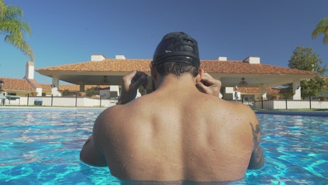 Swimmer in the pool seen from behind