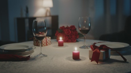Table ready for Valentine's Day celebration with wine and candles.