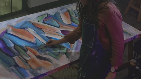 Talented female artist painting an abstract picture.