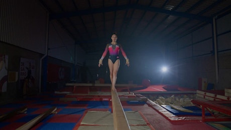 Talented gymnast practicing on a balance beam.