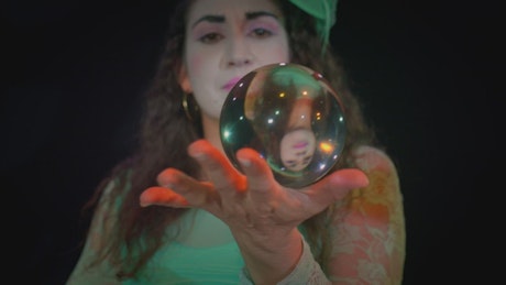 Talented woman doing tricks with a crystal sphere.