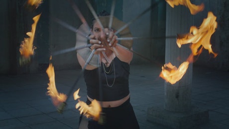Talented woman making a dance with fans in fire