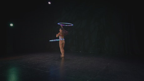Talented woman spinning two hula hoops.