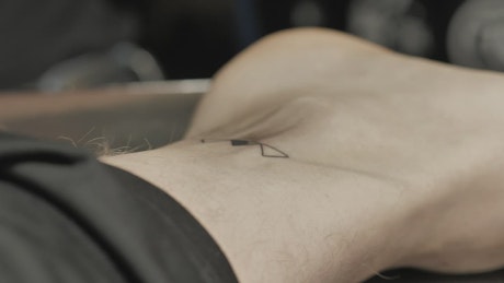 Tattoo artist making a minimalist tattoo