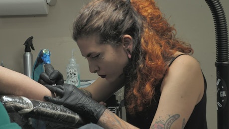 Tattoo artist working on a customer