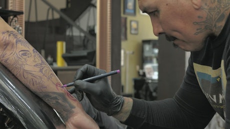 Tattooed tattooist working.