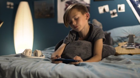 Team bone playing on a smartphone in the bed