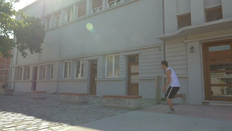 Teenager doing parkour down a street