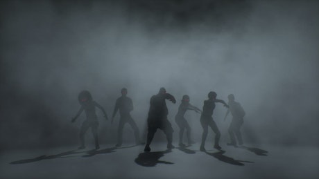 Terrifying group of zombies walking in a pack through smoke.