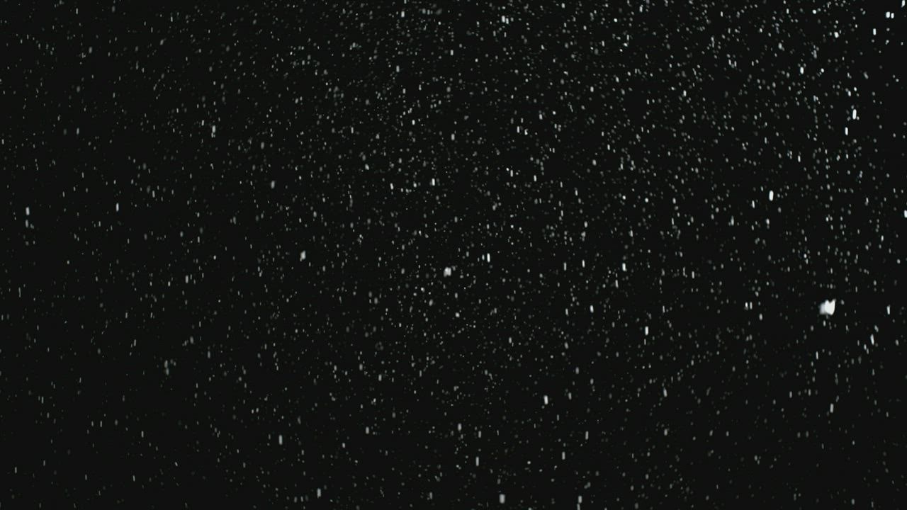 Texture of snow falling on black background - Free Stock Video