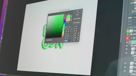 The graphic designer picks colors for the typography design on the computer..