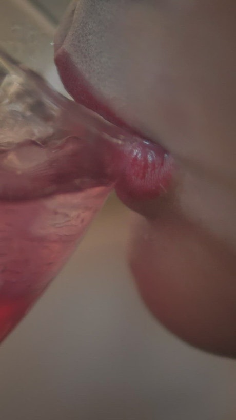 The mouth of a woman taking a cocktail.