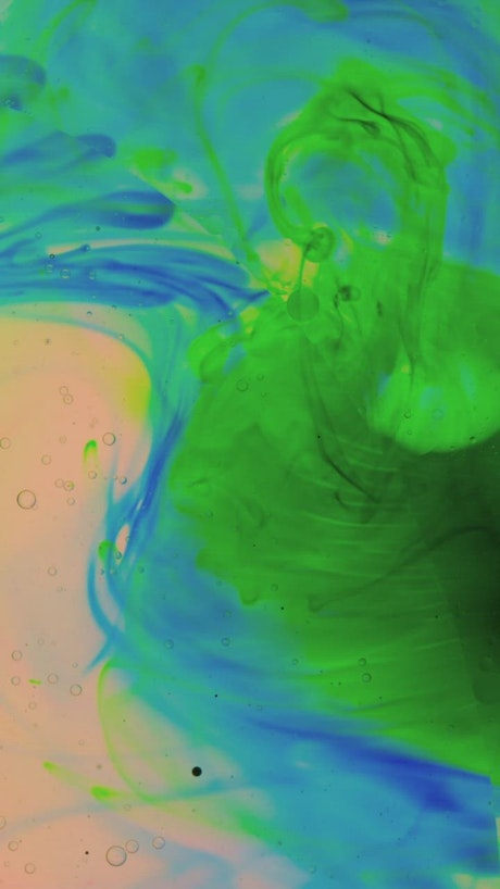 Thick colored inks flowing in an abstract video.