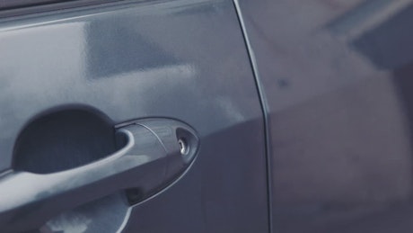 Thief unlocking a car door.