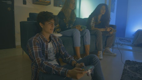 Three friends playing video games at night