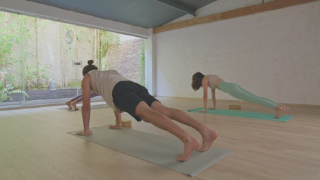 Three people doing yoga in a room.