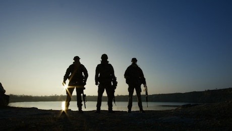 Three soldier silhouettes posign with guns