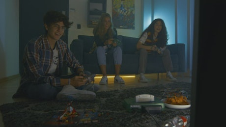 Three young friends playing video games