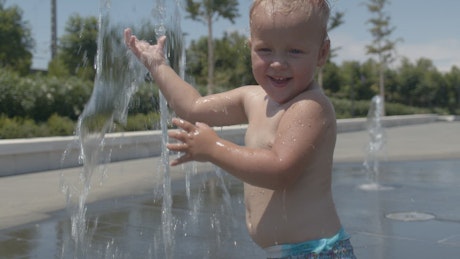 Toddler playing in a water fountain