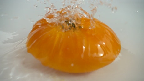Tomato falling into clear water