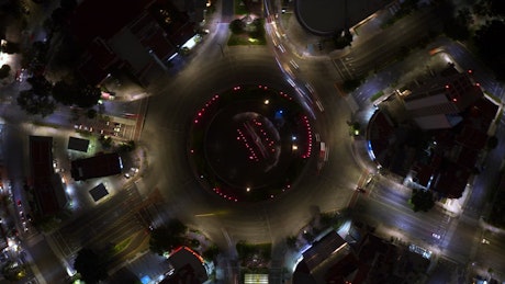 Top aerial video of the traffic around going a roundabout at night.