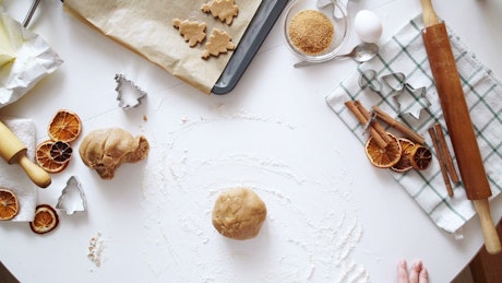 Top view of rolling cookie dough, cinnamon and baking tools