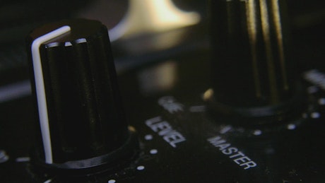 Touching the knobs on a dj mixer.