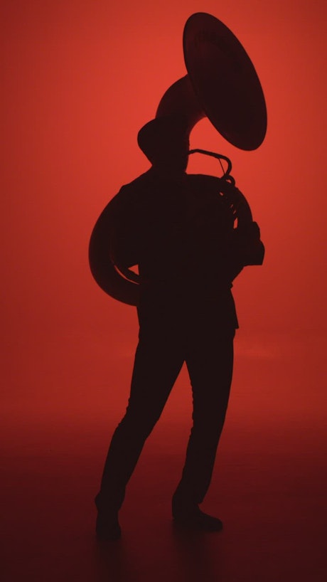 Trombone player in silhouette.