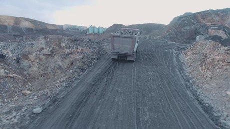 Truck loading rocks at a mining site.