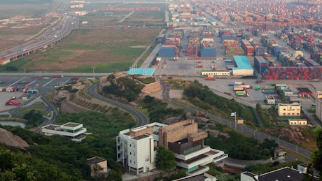 Trucks moving in a field of warehouses from above.