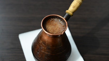 Turkish coffee pot with coffee inside.