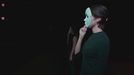 Two actresses finished their act with masks in a theater.