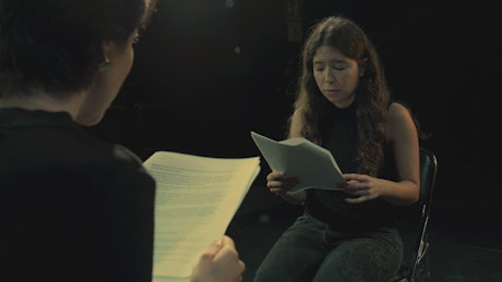 Two actresses rehearsing a script together.