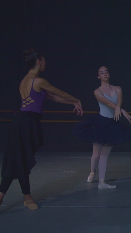 Two ballet dancers practicing movements.