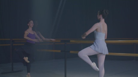 Two ballet dancers rehearsing at the bars.